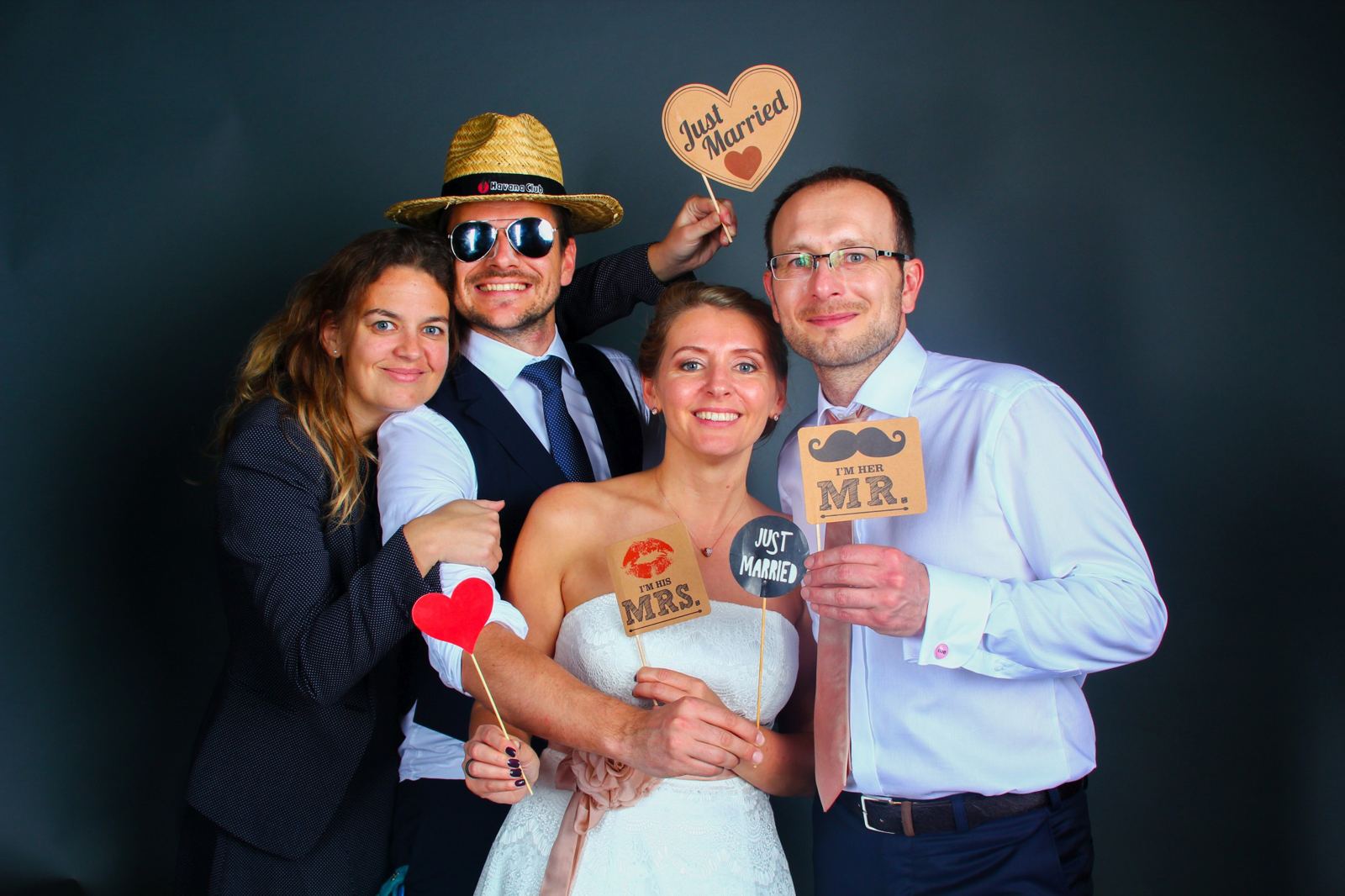 Brautpaar mit Freunden und Just-Married-Schildern